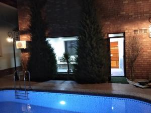 una piscina en un edificio con dos palmeras en Green House ECO HOTEL, en Samarkand