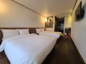 Postel nebo postele na pokoji v ubytování Tamara Jeju hotel