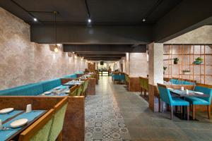 a dining room with blue tables and blue chairs at Time Square Boutique Hotel & Spa in Alleppey