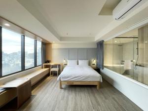 a bedroom with a bed and a tub and a shower at Green Hotel - Midori in Taichung