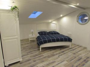 1 dormitorio con 1 cama y tragaluz en Le Parc - Suite climatisée, en Magrie