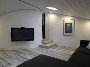 sala de estar con TV de pantalla plana en la pared en Le Parc - Suite climatisée, en Magrie