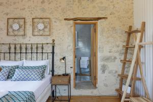 a bedroom with a bed and a ladder and a mirror at Anna's Villa in Mesi Village in Agia Triada