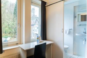 ein Bad mit einem Waschbecken, einem WC und einem Fenster in der Unterkunft Huis Ter Geul in Valkenburg