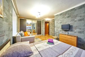 a bedroom with a bed and a tv on a wall at Apartment Gazeta Zvezda 75 in Perm