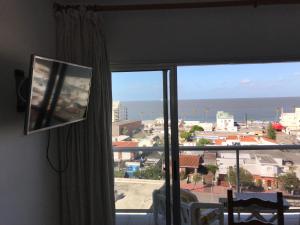 Cette chambre dispose d'une fenêtre offrant une vue sur l'océan. dans l'établissement Piriapolis apartamento, à Piriápolis