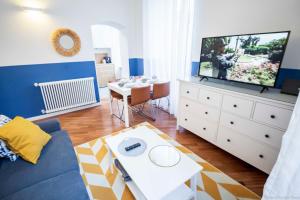 a living room with a tv and a couch and a table at Toffee Gioberti - Seven Suites Sanremo in Sanremo