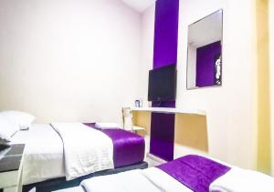 Habitación de hotel con 2 camas y espejo en Biz Hotel, en Batu Pahat