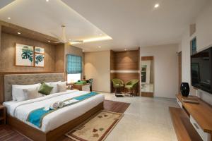 a hotel room with a bed and a television at Time Square Boutique Hotel & Spa in Alleppey