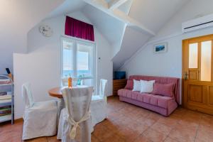 sala de estar con sofá rosa y mesa en Villa Stella, en Splitska