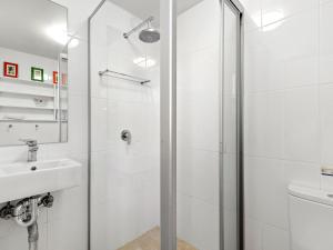 a white bathroom with a shower and a sink at Time To Unwind in Culburra Beach +17 photos