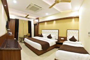 ein Hotelzimmer mit 2 Betten und einem Schreibtisch in der Unterkunft Hotel Amritsar International in Amritsar