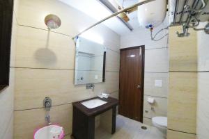 Hotel Amritsar International في أمريتسار: حمام مع حوض ومرحاض ومرآة