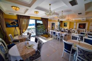 a restaurant with tables and chairs and a large window at Adonis Zlatibor 205 in Zlatibor