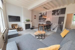 Una sala de estar con un sofá azul y una mesa. en Appartement De Croone, en Middelburg