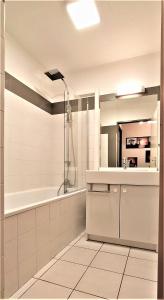 a bathroom with a shower and a sink and a tub at Cocoon'Inn Blagnac in Blagnac