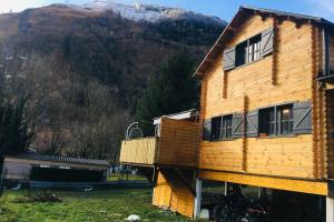 a wooden house with a mountain in the background at Chalet Bois Laruns in Laruns
