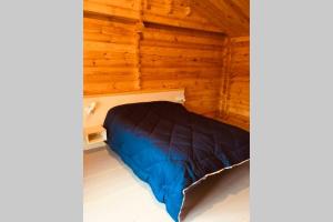1 dormitorio con 1 cama en una cabaña de madera en Chalet Bois Laruns en Laruns