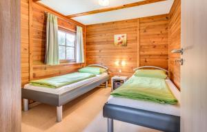 two beds in a room with wooden walls at Bartlhof-Ferienwohnungen-Zimmer in Burglengenfeld