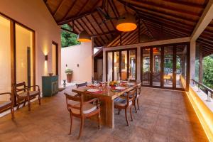 a dining room with a wooden table and chairs at Sea Heart House on Koggala Lake in Koggala