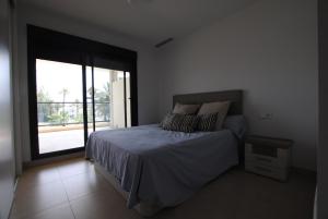 - une chambre avec un lit et une grande fenêtre dans l'établissement 196 Terrazas de Las Marinas - Deniasol, à Dénia