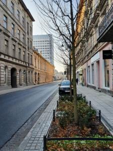 un coche aparcado al lado de una calle de la ciudad en Takie studio, że żal nie wynająć, en Łódź