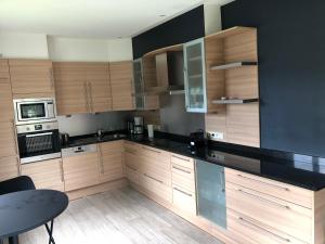 a kitchen with wooden cabinets and a black counter top at Villa les Tamaris in Spa