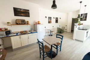 uma cozinha e sala de jantar com mesa e cadeiras em Giglio Marino em Tortolì