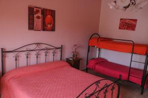 a bedroom with two bunk beds with red sheets at Sogno Salento in Guagnano