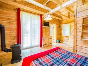 a bedroom with a bed in a log cabin at Witalna Osada Helonowo in Ropienka