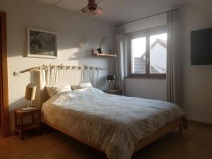 Schlafzimmer mit einem Bett und einem Fenster in der Unterkunft chambre d'hôtes de charme, un temps en forêt in Westhouse