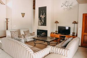 a living room with two couches and a fireplace at 119 Zebula in Mabula