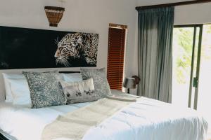 a bedroom with a bed with a painting of a leopard at 119 Zebula in Mabula
