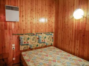 1 dormitorio con 1 cama en una pared de madera en Kione Calgary, en Pas de la Casa