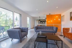 a living room with two couches and a table at Appartement Duplex Jardin in Sévrier