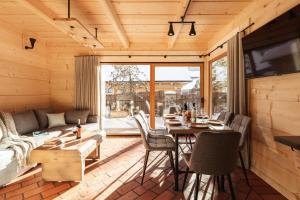 - un salon avec une table, des chaises et un canapé dans l'établissement Baran, domek z widokiem na Giewont, à Zakopane