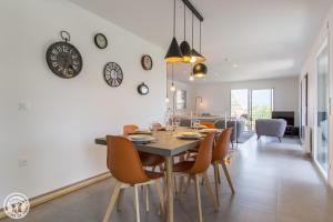 a dining room and living room with a table and chairs at Appartement Duplex Jardin in Sévrier