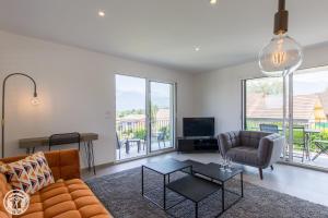 a living room with a couch and a table at Appartement Duplex Jardin in Sévrier