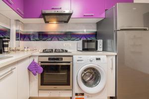 a kitchen with a stove and a washing machine at Apartamente Lavender Coressi in Braşov