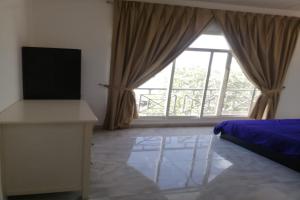 a bedroom with a bed and a large window at OYO 621 Home Habtoor studio's in Dubai