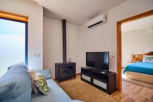 a living room with a blue couch and a television at Quinta do Lordelo Turismo Rural in Penafiel