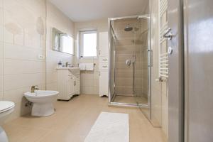 a white bathroom with a shower and a toilet at Apartamente Lavender Coressi in Braşov +16 photos