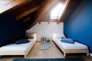 2 letti in una camera con parete blu di Modern Luxury Attic - byMyHomeInComo a Como