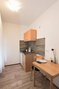 a kitchen with a wooden table and a dining room at City Apart Hotel in Düsseldorf