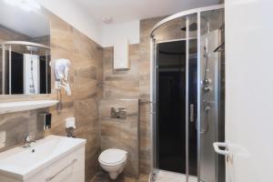 a bathroom with a shower and a toilet and a sink at City Apart Hotel in Düsseldorf