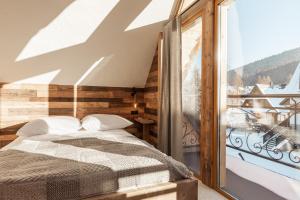 a bedroom with a bed and a large window at Baran, domek z widokiem na Giewont in Zakopane