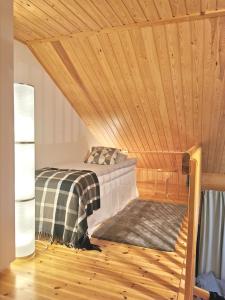 a bed in a room with a wooden ceiling at Gold Legend Paukkula #1 - Saariselkä Apartments in Saariselka