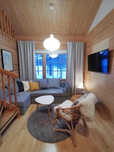 uma sala de estar com um sofá azul e uma televisão em Gold Legend Paukkula #1 - Saariselkä Apartments em Saariselka