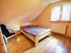 a small bedroom with a bed and a window at Witalna Osada Helonowo in Ropienka