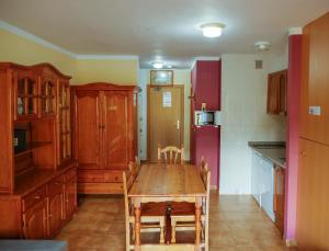 cocina con mesa de madera y nevera en Kione DeuSol, en Incles